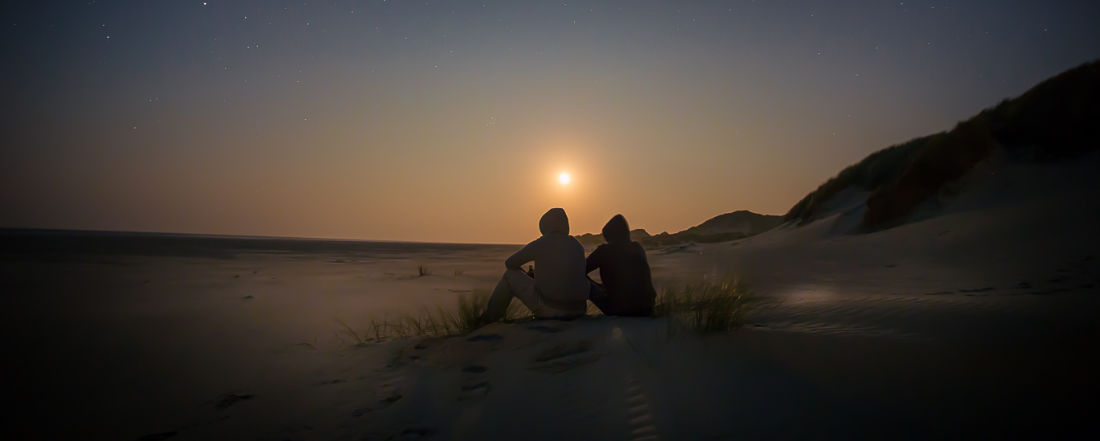 Due persone sedute al tramonto